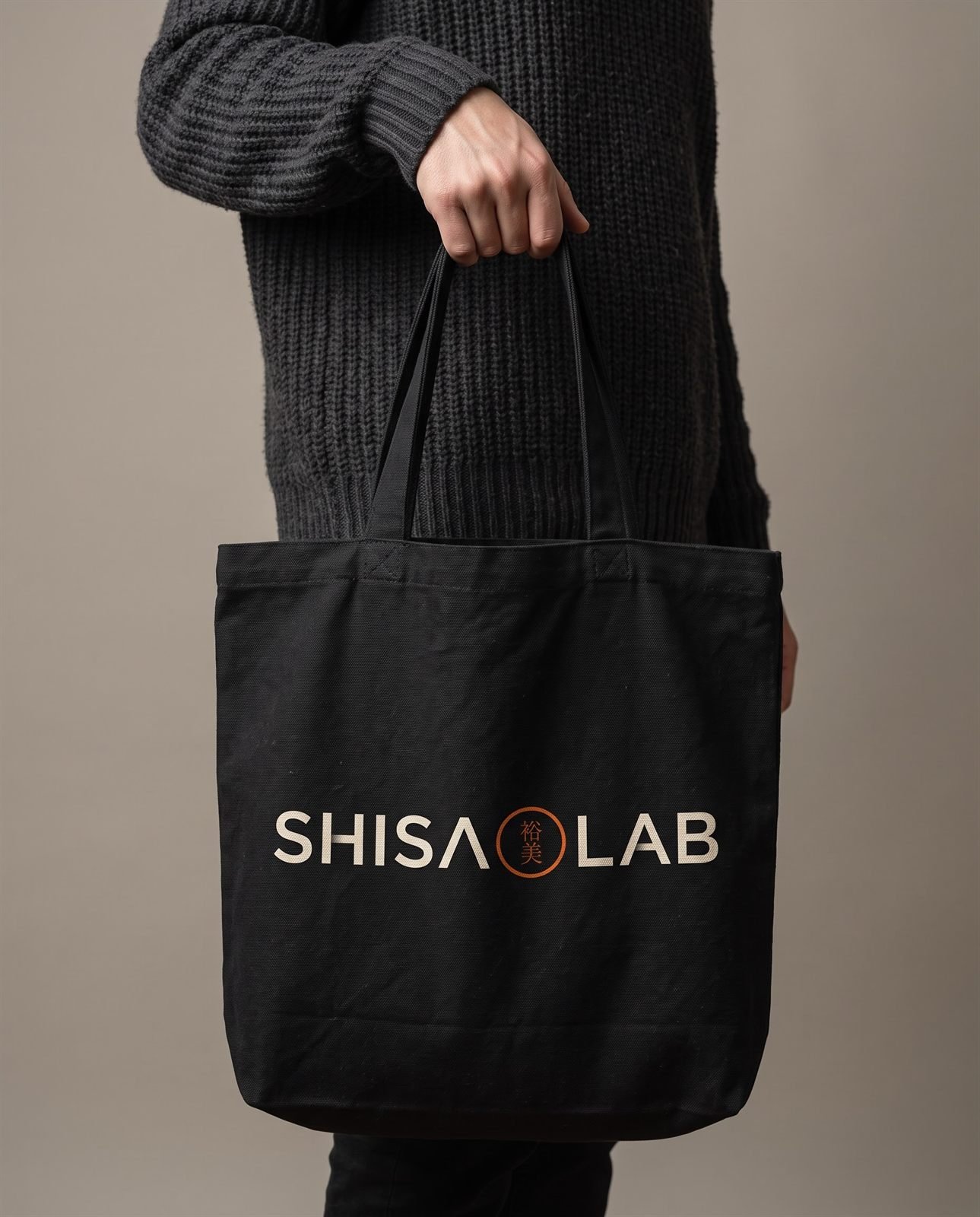 Ecobag preta de lona com o logo Shisa Lab serigrafado em marfim
