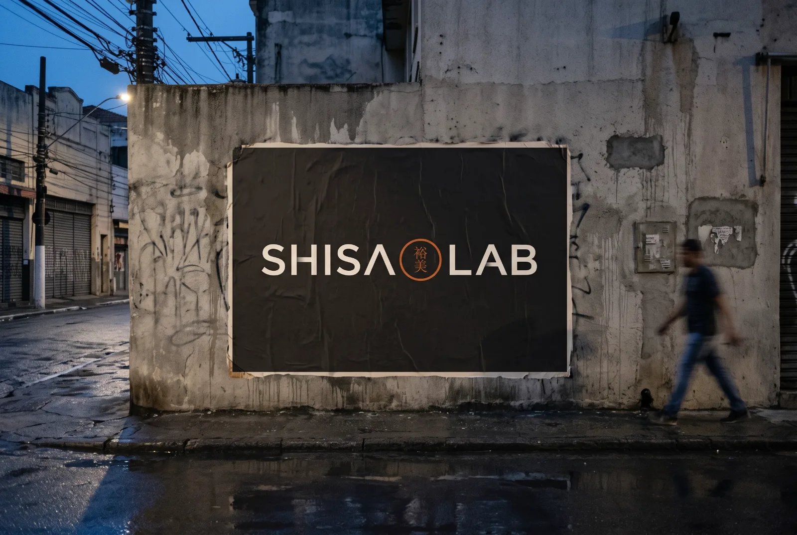 Cartaz preto com o logo Shisa Lab colado em muro de concreto numa rua de São Paulo