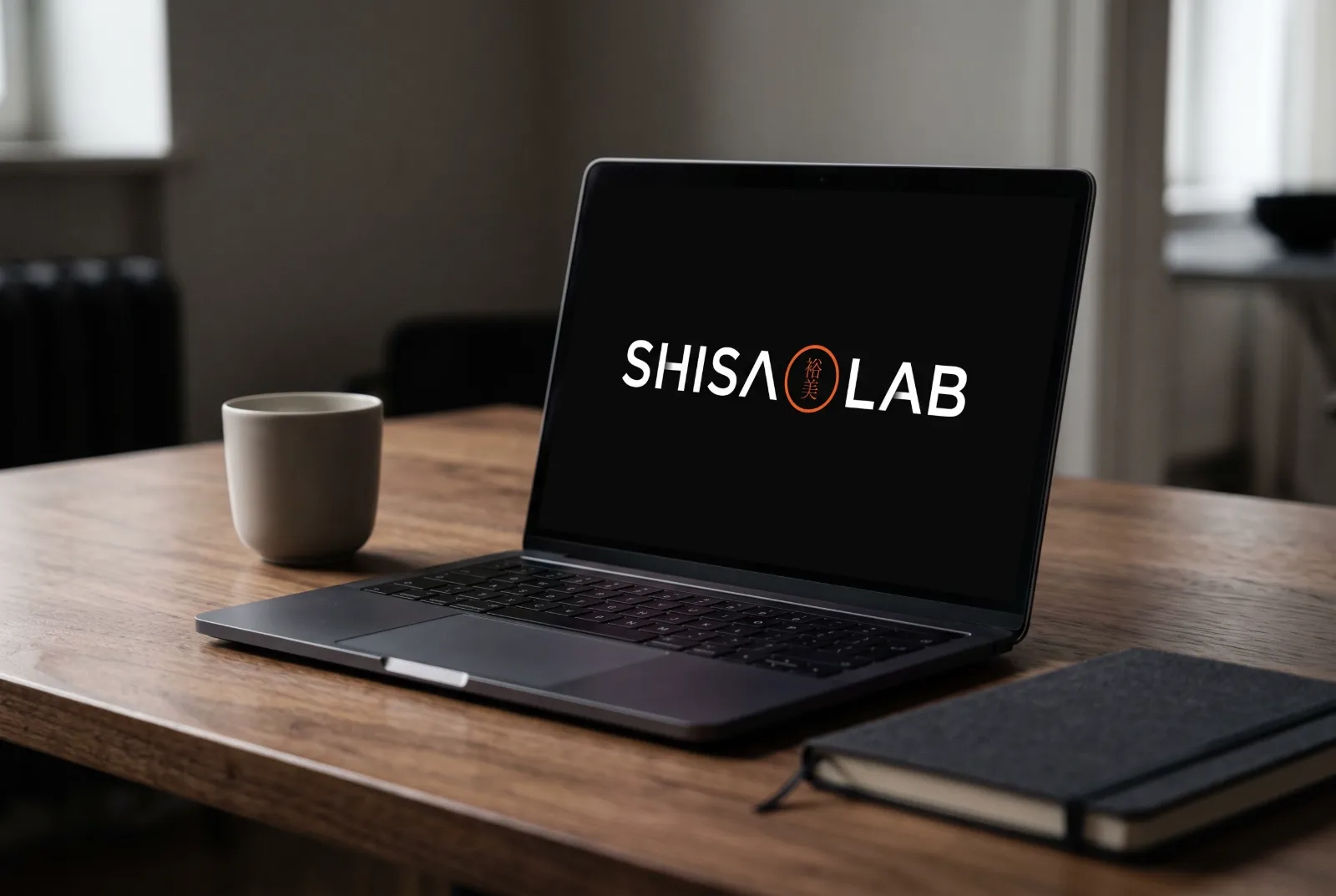 Laptop aberto sobre mesa de madeira exibindo o logo Shisa Lab na tela