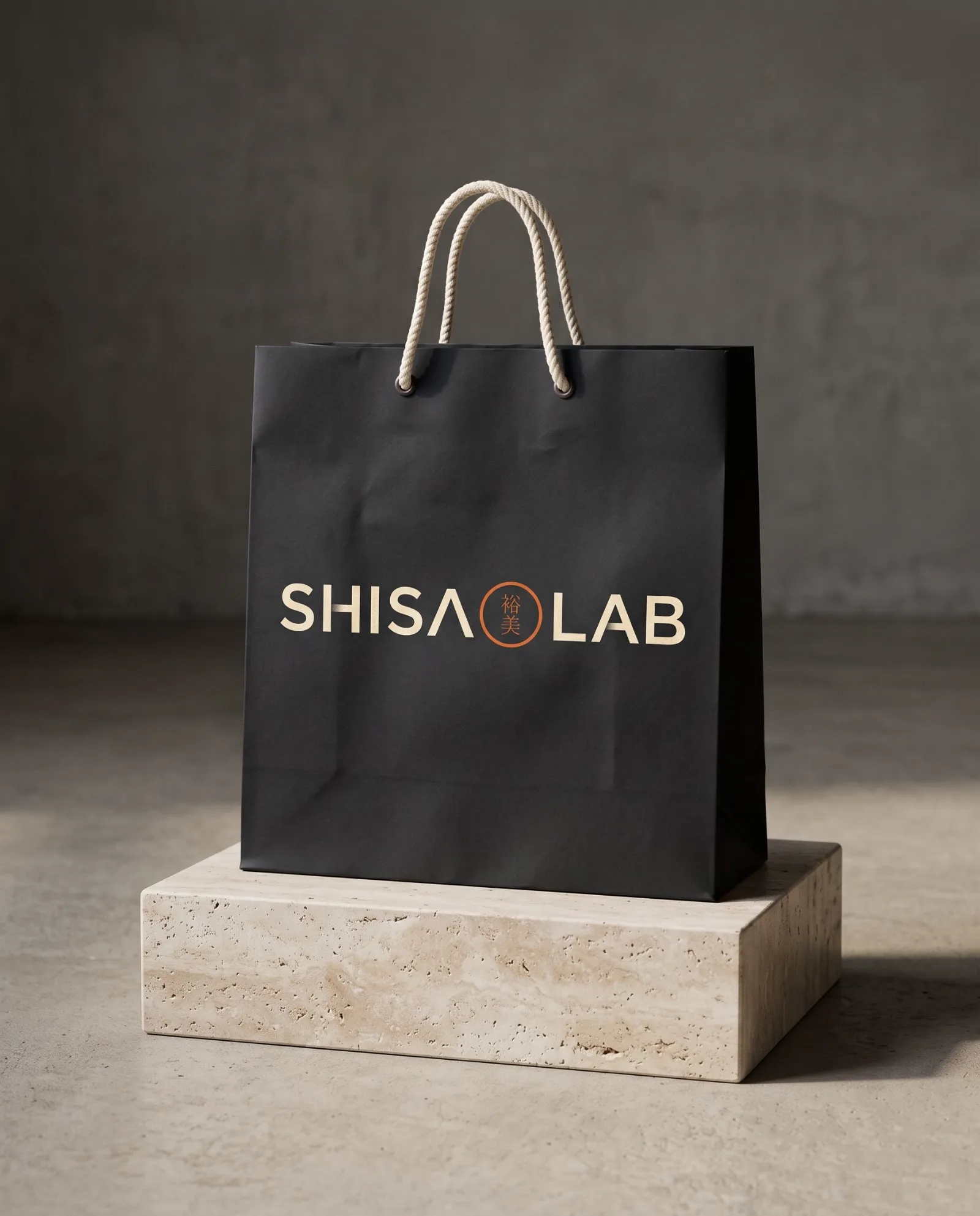 Sacola de papel preta com o logo Shisa Lab sobre base de travertino